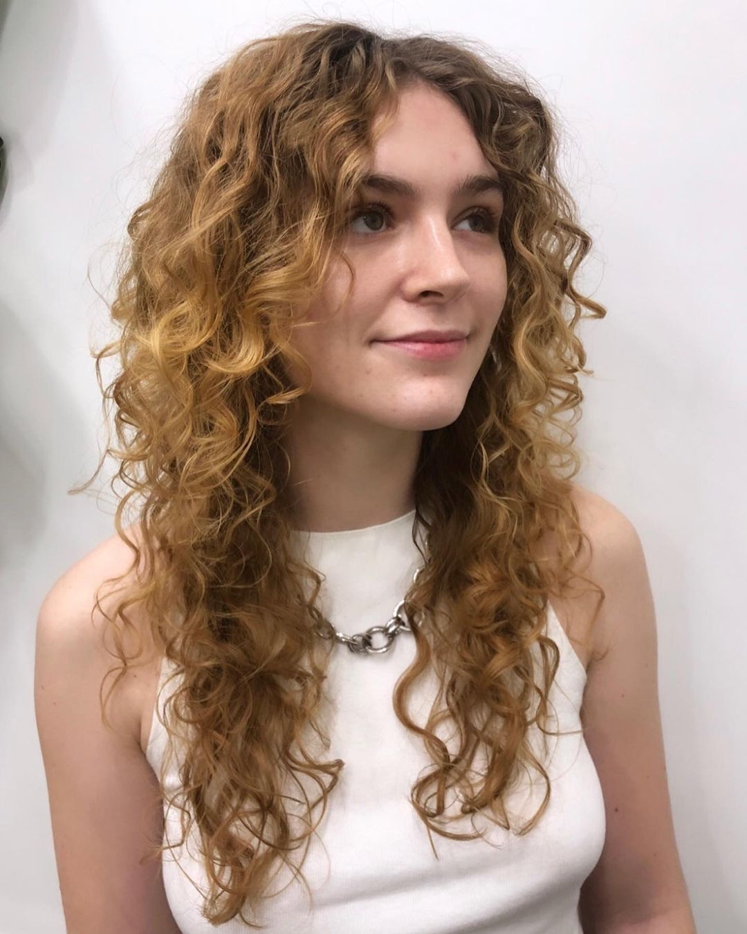 Long curly hair with curtain bangs