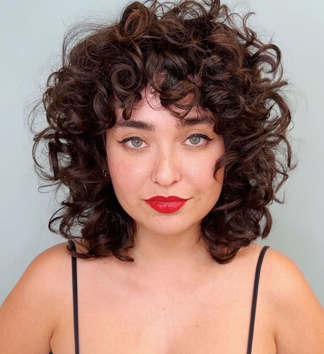 Shoulder-length rounded curly shag with bangs