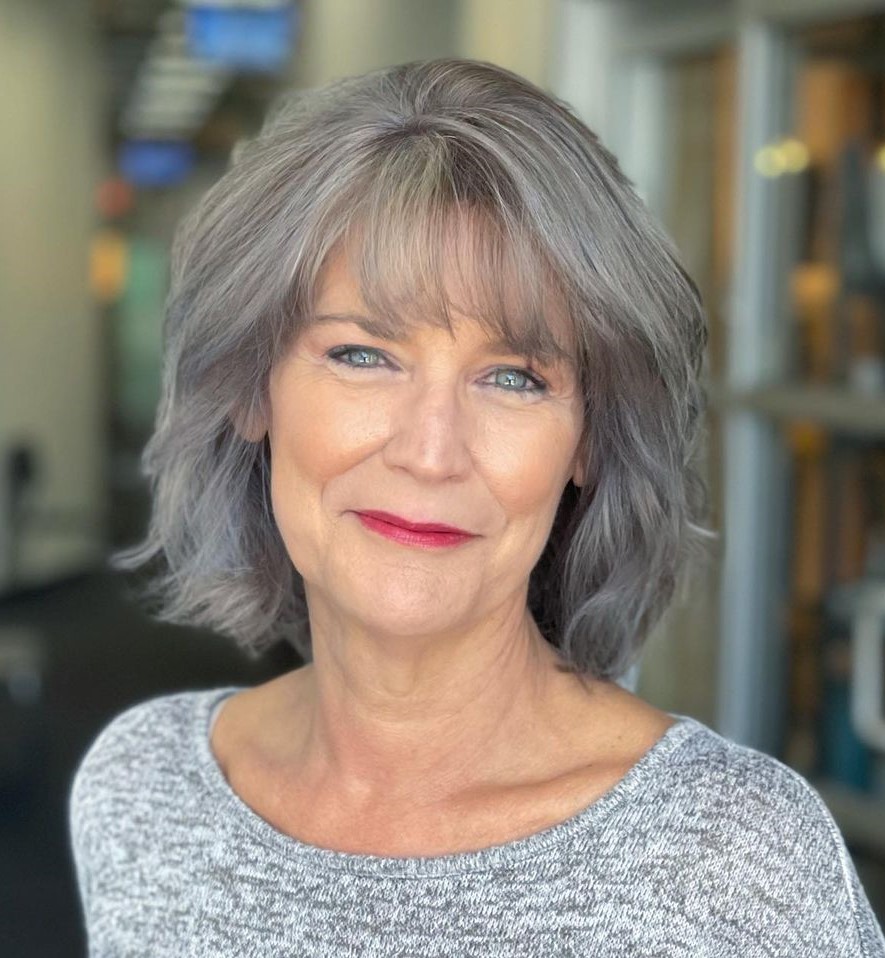 Image of Layered cut with curtain bangs hairstyle for women over 50