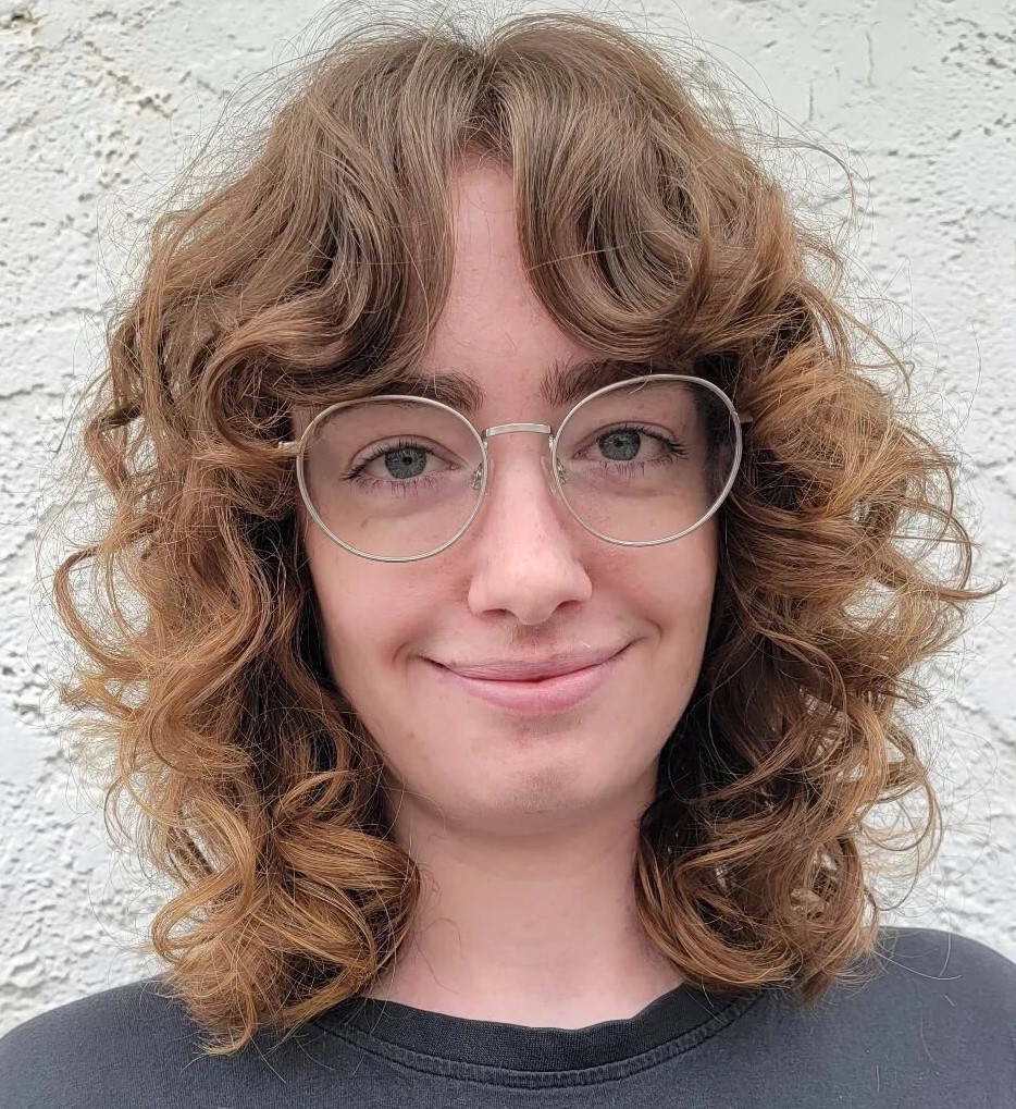 Curly bob with curtain bangs pushed wide to the sides