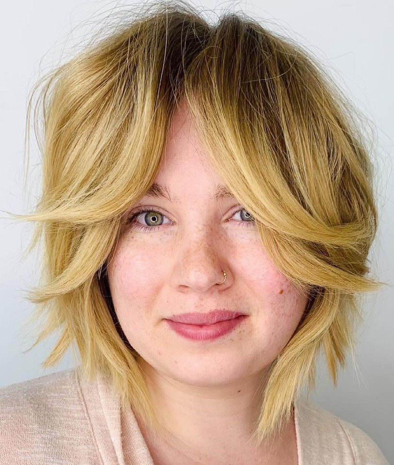 Short blonde cut with curtain bangs flipped to the sides
