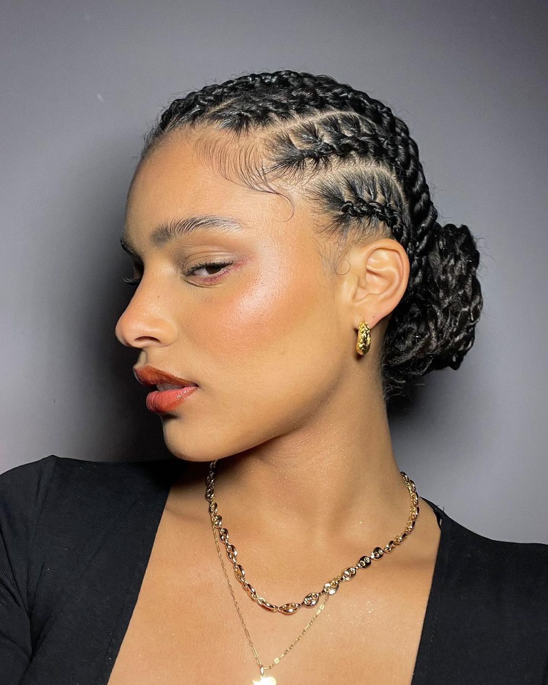 Twisted cornrows gathered into a low bun at the nape