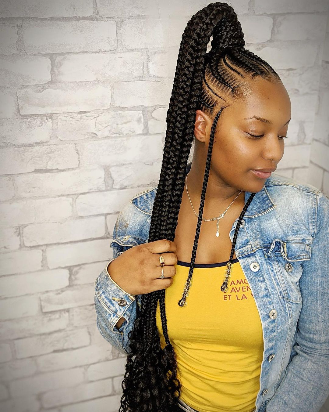 Straight-back cornrows gathered into a braided ponytail with face-framing braids