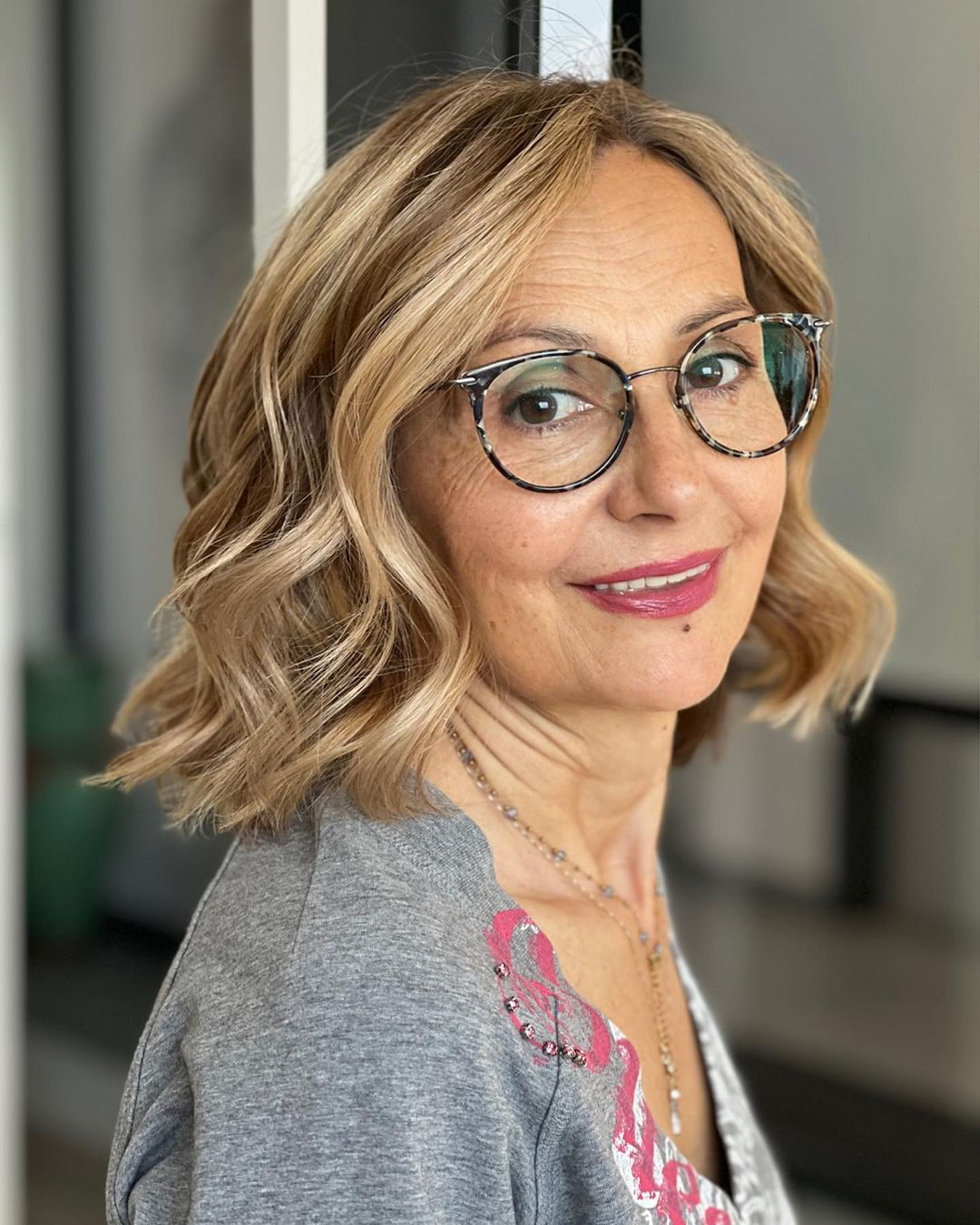 Wavy Bob with Blonde Balayage on a Woman with Glasses