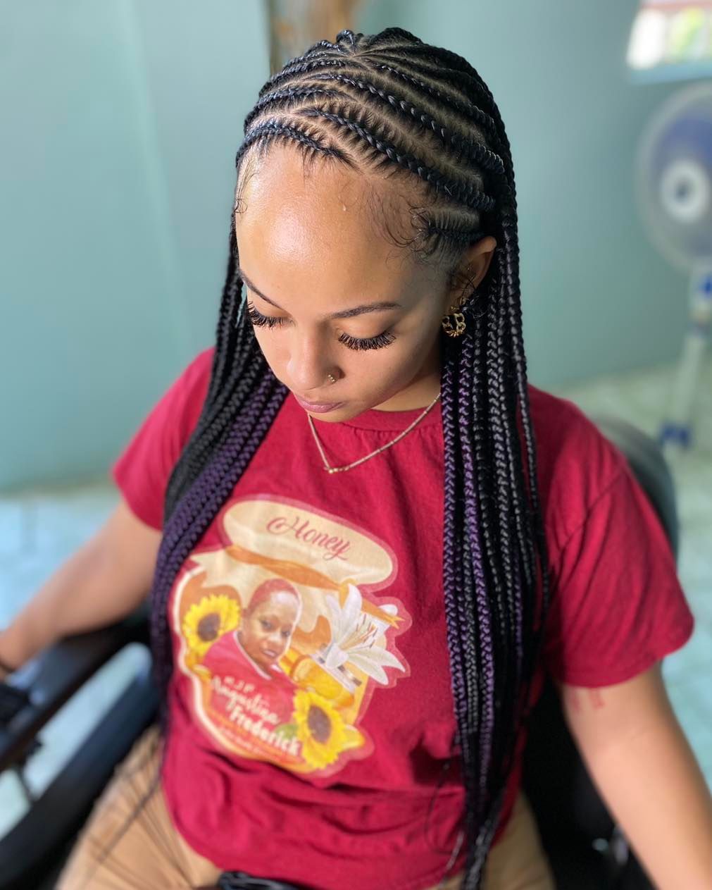 Fulani-inspired cornrows to the back with purple feed-in highlights